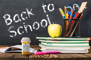 A chalkboard has "Back to School" written on it; a desk includes school supplies, an apple and a prescription drug bottle